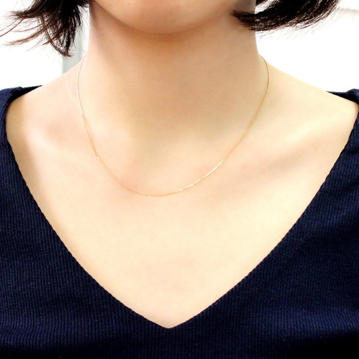 喜平チェーン K18 18金 ゴールド 2面ダイヤカット ネックレス チェーン 0.65mm 40cmを着用している女性