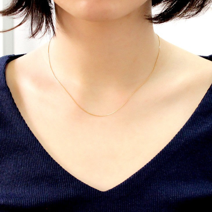 ベネチアンチェーン K18 18金 ゴールド 4面ダイヤカット ネックレス チェーン 0.5mm 40cmを着用している女性