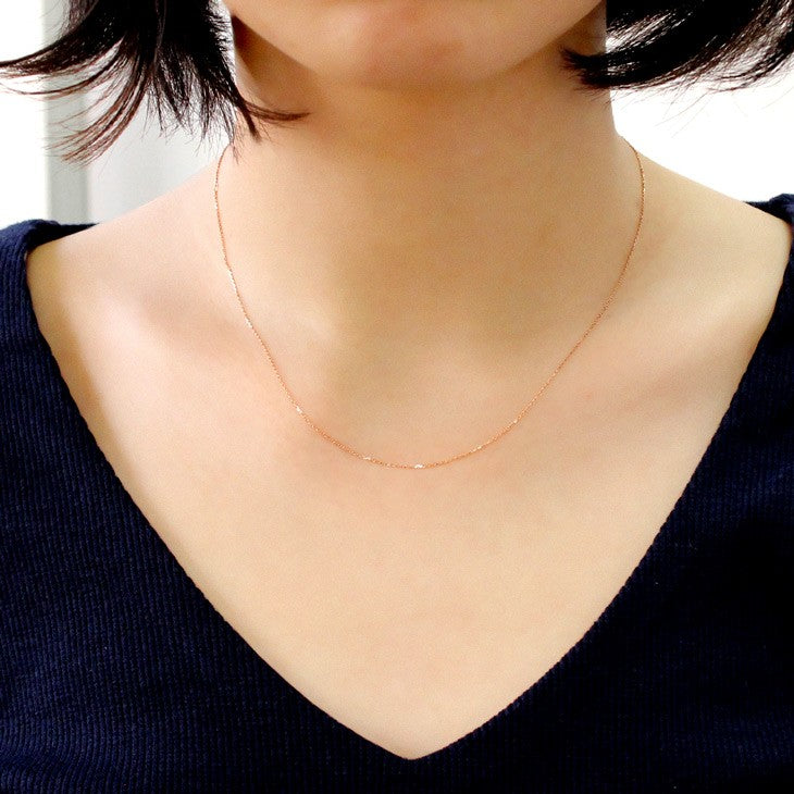 あずきチェーン K10PG 10金 ピンクゴールド 4面ダイヤカット  ネックレス チェーン アズキ 小豆 0.7mm 40cmを着用している女性